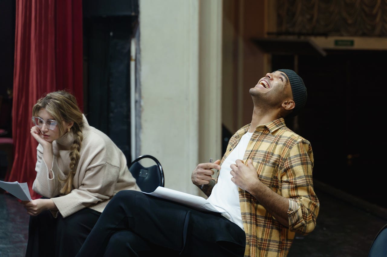 Two actors rehearsing a scene in a theater, showcasing emotions and expression.